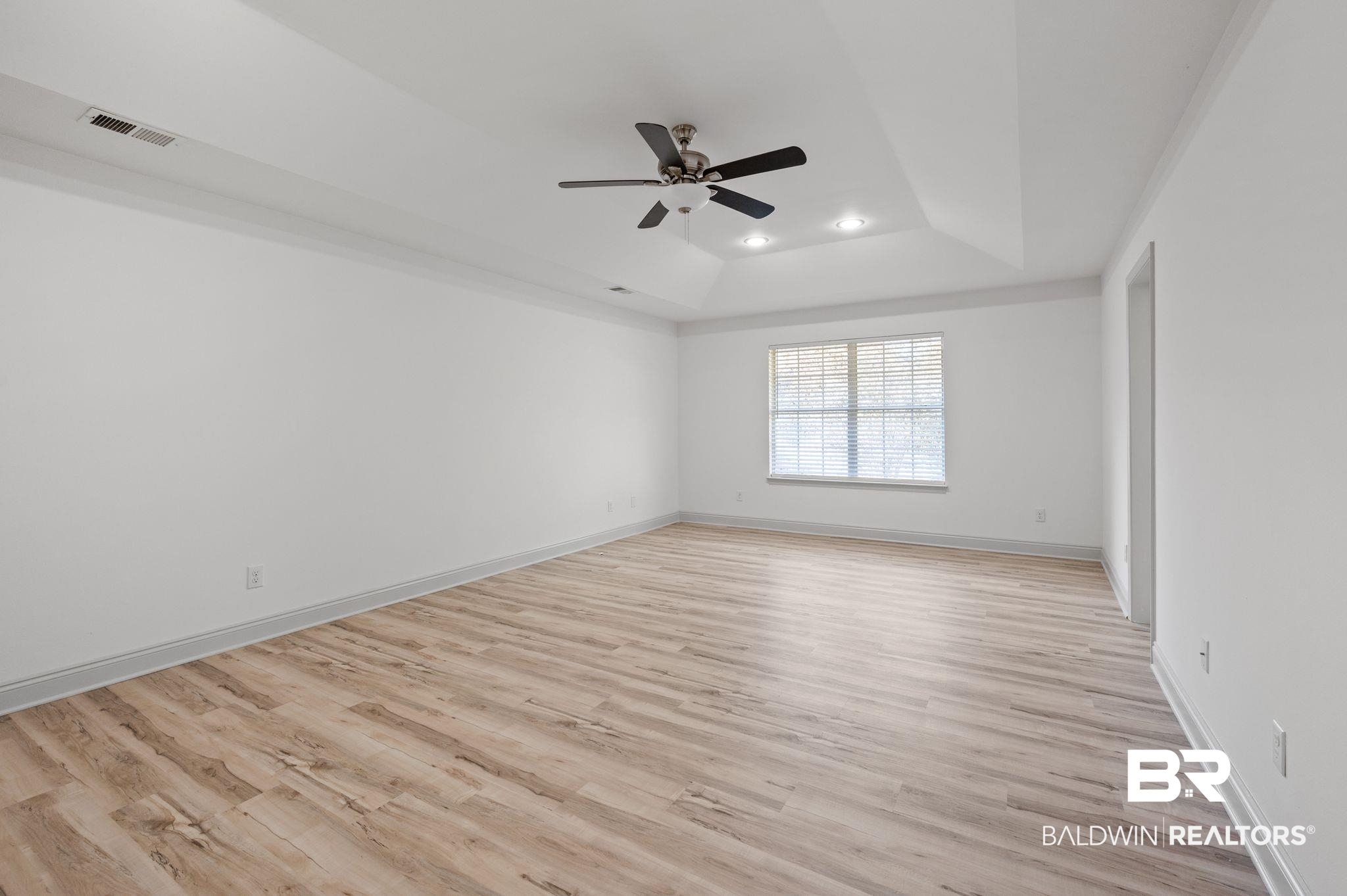 136 Destrehan Road Fairhope, AL 36532 - Photo 30 of 44 Spare room featuring a raised ceiling, light hardwood / wood-style flooring, and ceiling fan