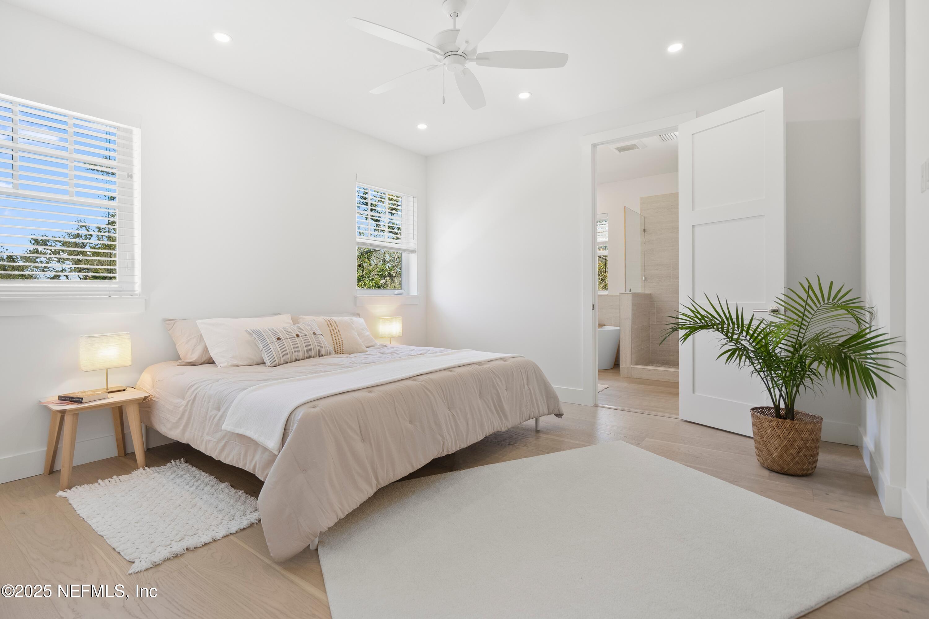 168 Surfside Avenue St. Augustine, FL 32084 - Photo 16 of 28 a bedroom with a large bed and a potted plant