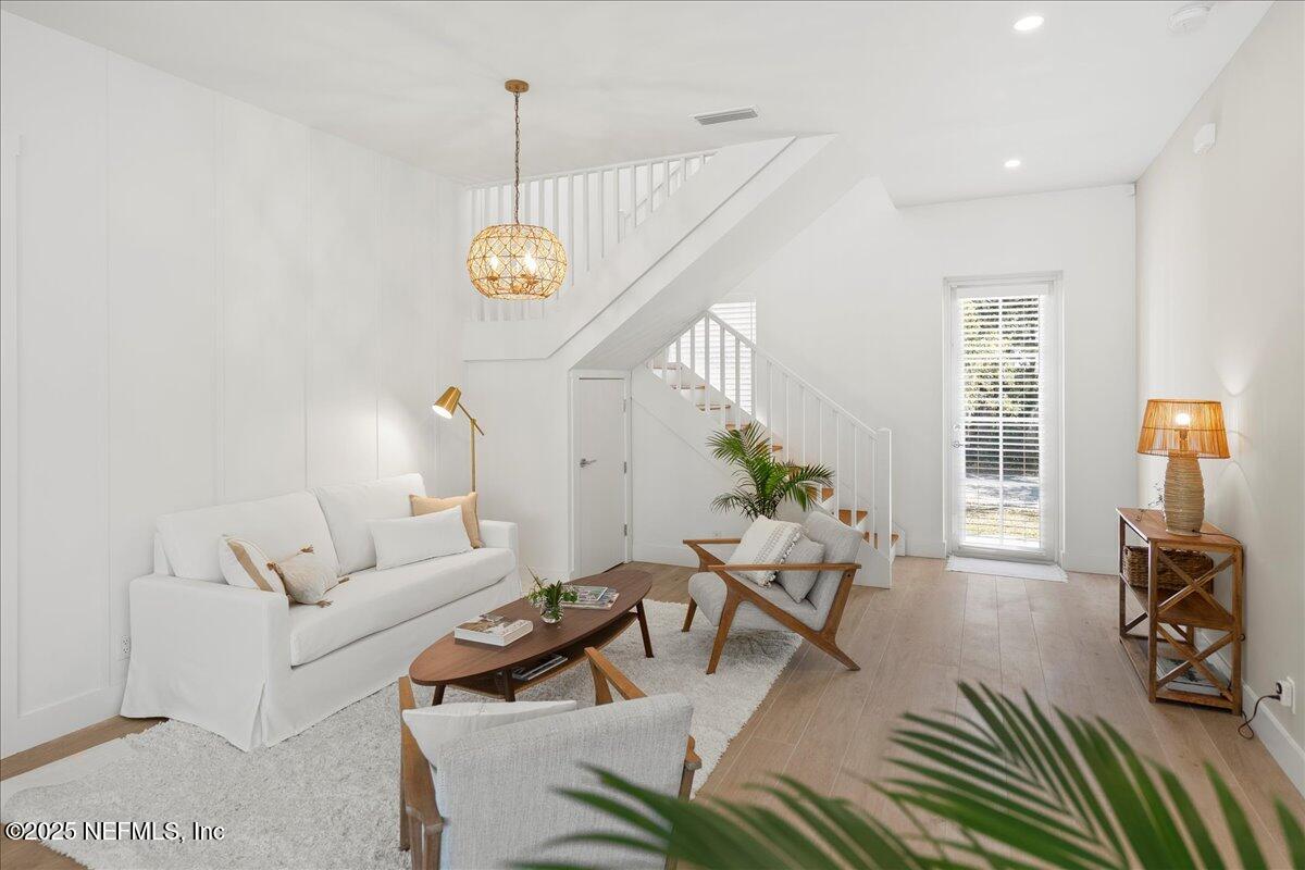 168 Surfside Avenue St. Augustine, FL 32084 - Photo 5 of 28 a living room with furniture a dining table and a chandelier