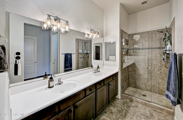 a bathroom with a double vanity sink mirror and shower