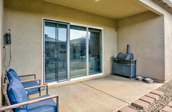 a view of pool with lawn chairs under an umbrella
