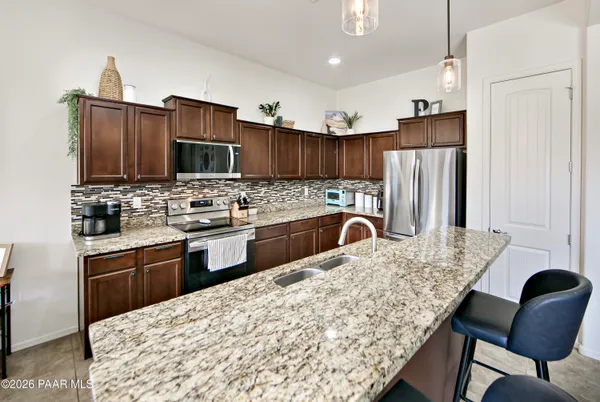 a kitchen with stainless steel appliances granite countertop a stove refrigerator sink and cabinets