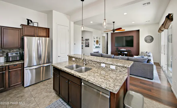 a kitchen with stainless steel appliances granite countertop a sink refrigerator and microwave