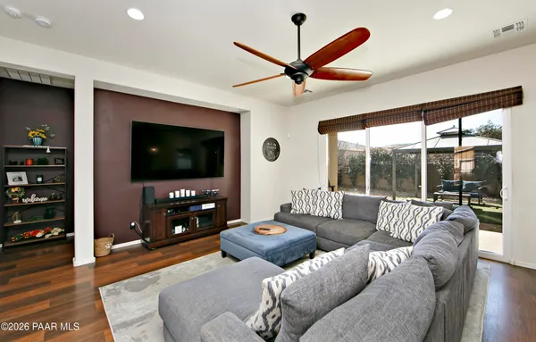 a living room with furniture a flat screen tv and a floor to ceiling window