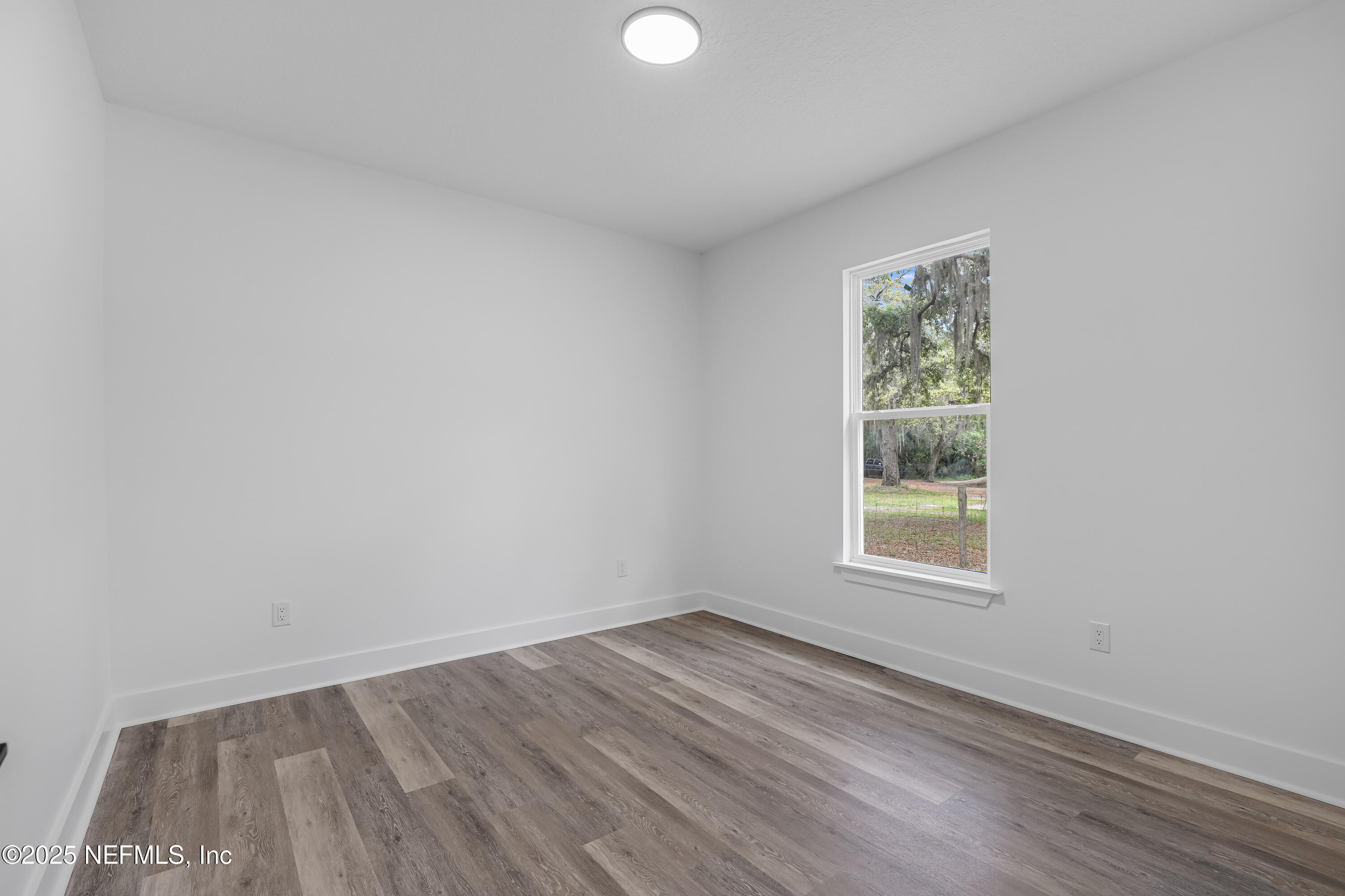 12092 Sheffield Road Jacksonville, FL 32226 - Photo 16 of 55 an empty room with wooden floor and windows