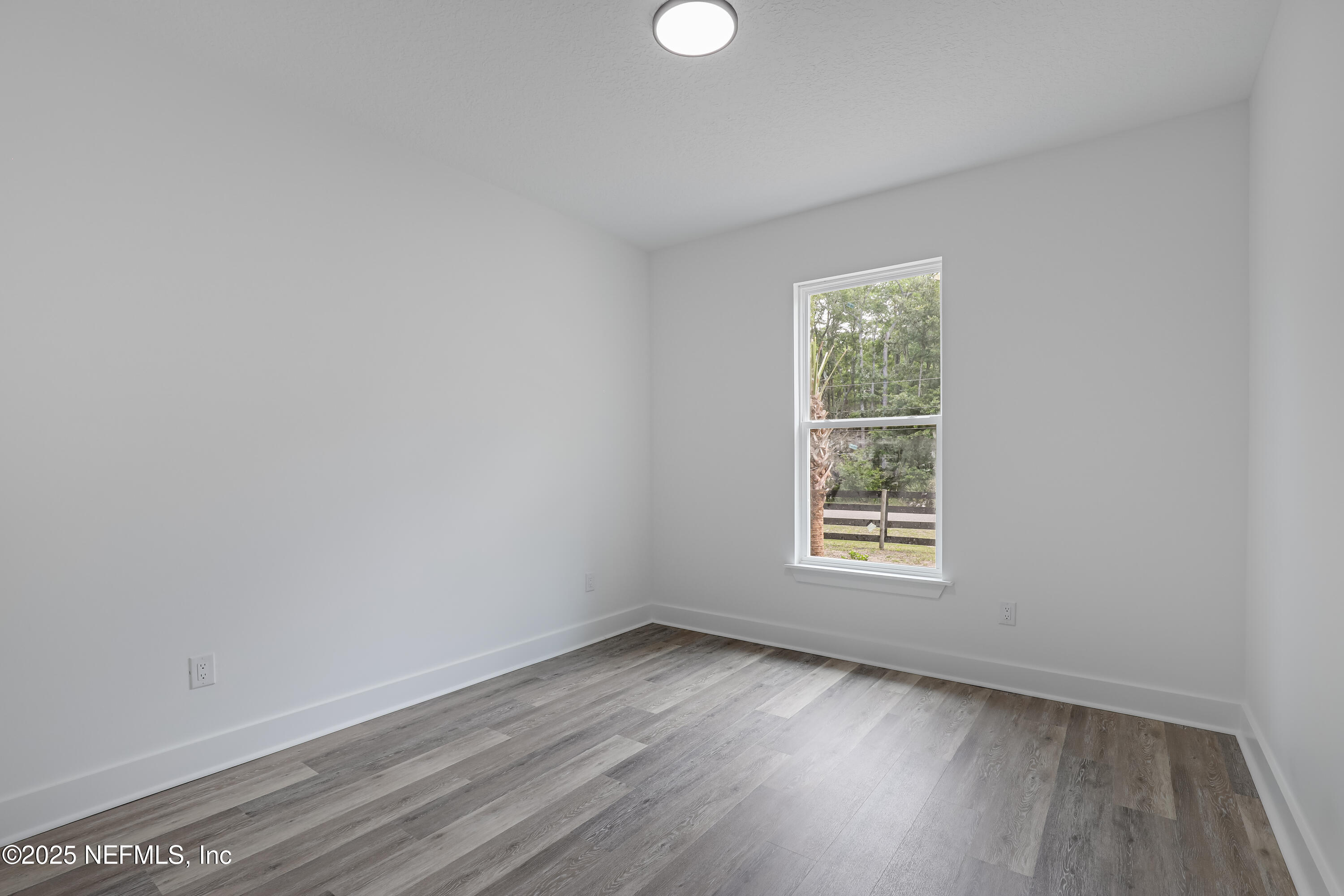 12092 Sheffield Road Jacksonville, FL 32226 - Photo 18 of 55 an empty room with wooden floor and windows