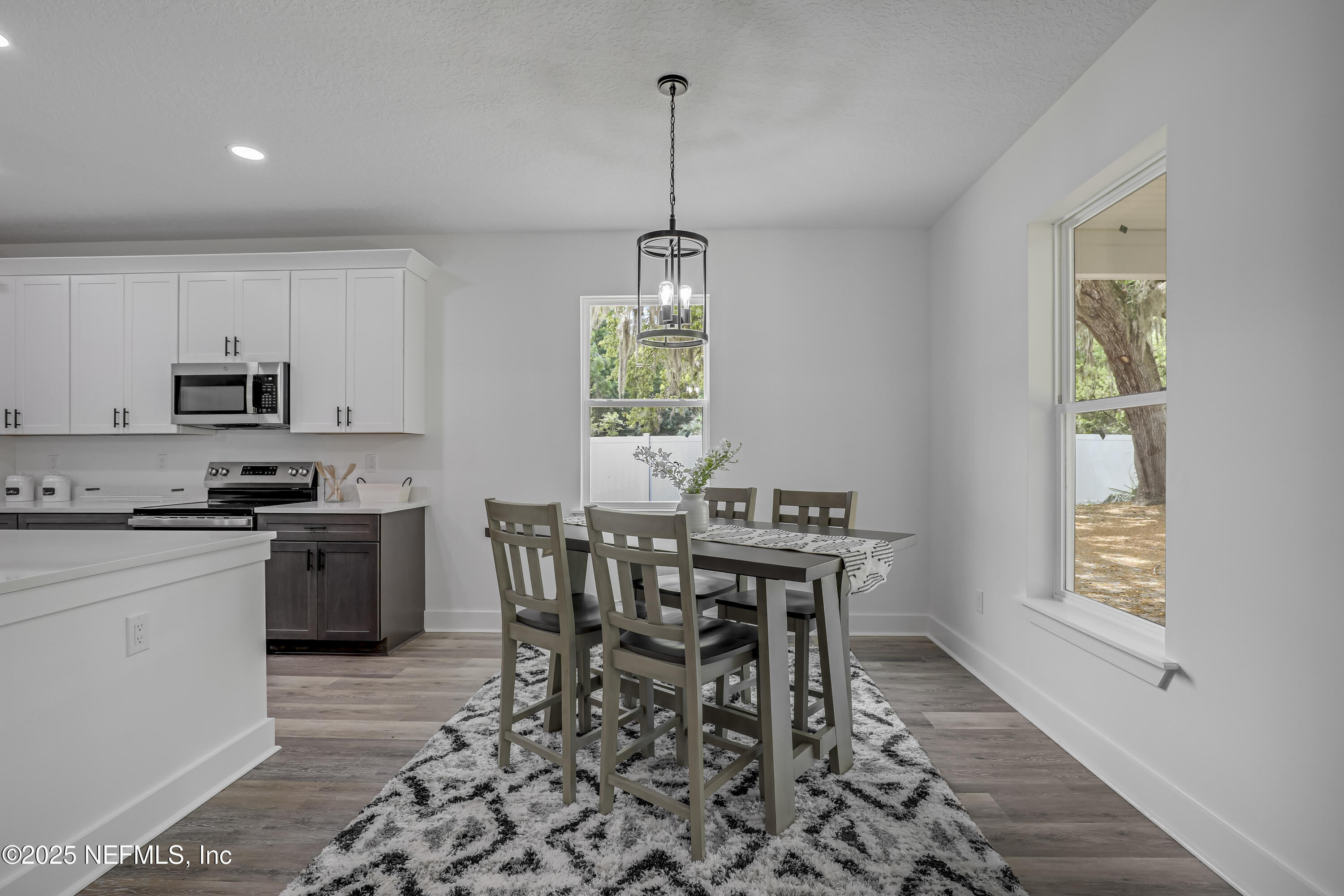 12092 Sheffield Road Jacksonville, FL 32226 - Photo 30 of 55 a kitchen with stainless steel appliances granite countertop a stove top oven a sink a dining table and chairs with wooden floor