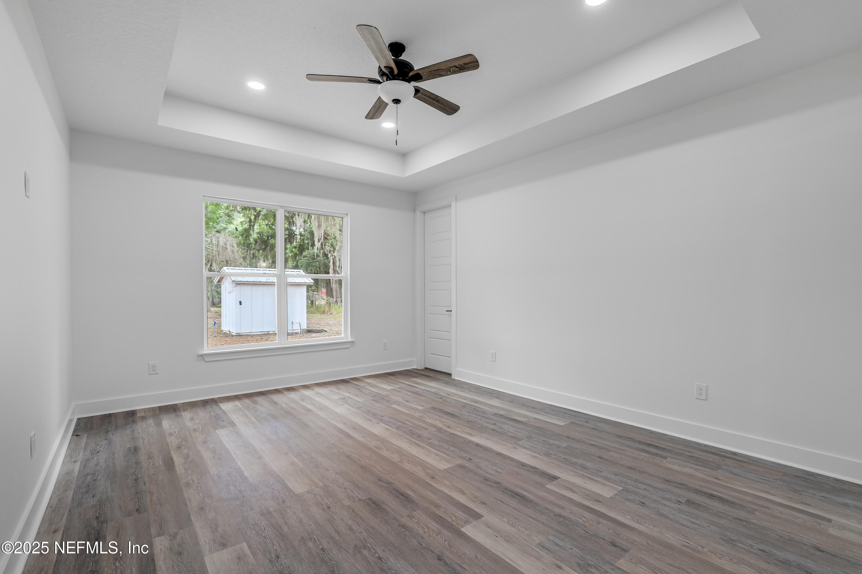 12092 Sheffield Road Jacksonville, FL 32226 - Photo 33 of 55 an empty room with wooden floor ceiling fan and window