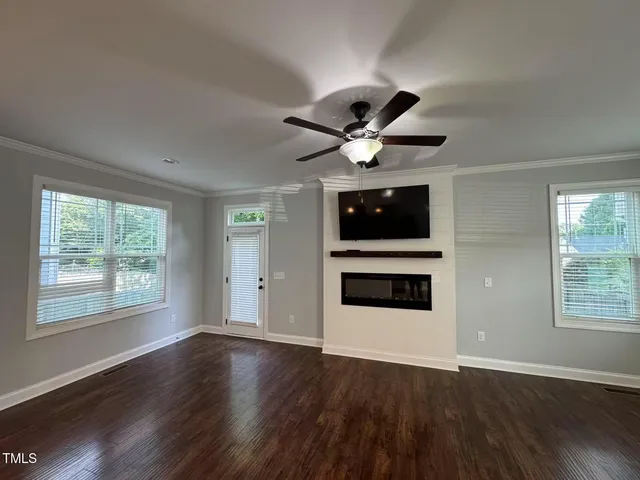 a view of a big room with wooden floor and ceiling fan