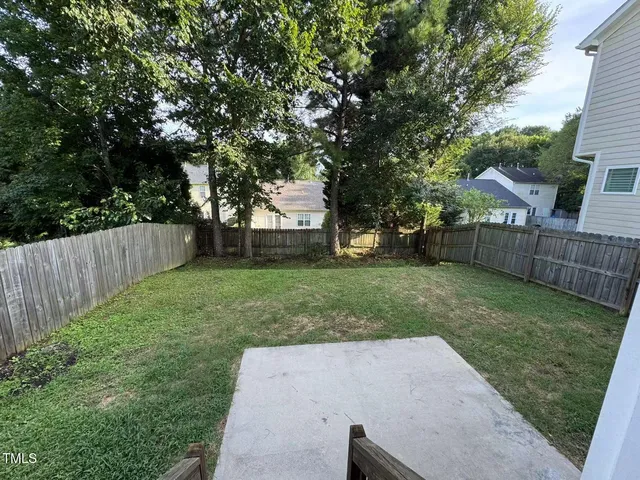 a view of a yard with wooden fence