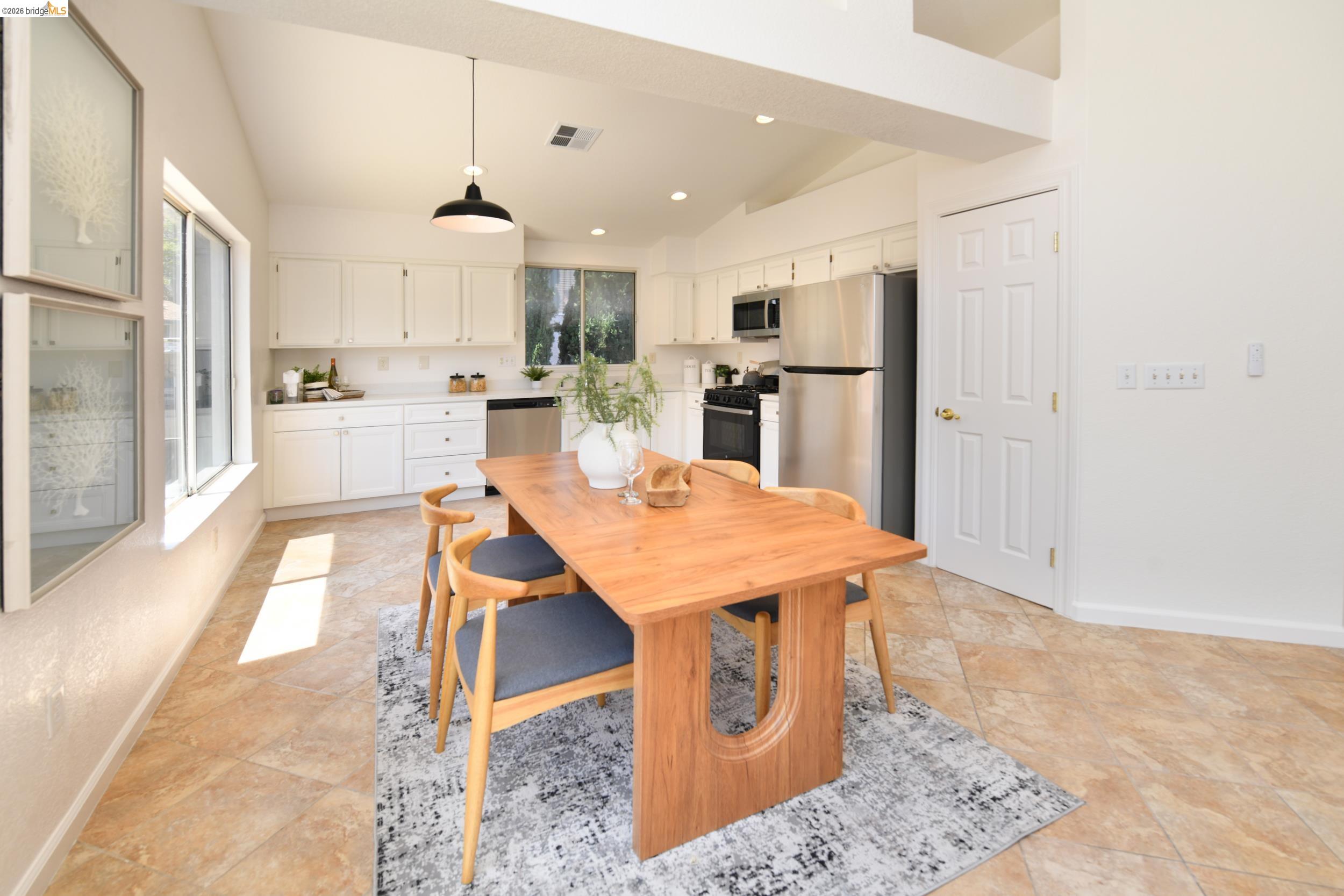 512 Burdick Drive Bay Point, CA 94565 - Photo 19 of 50 Open-concept kitchen featuring white cabinetry, stainless steel appliances, and a tile backsplash