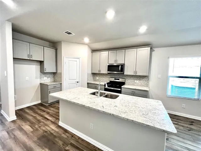 a kitchen with a refrigerator a stove a microwave and cabinets