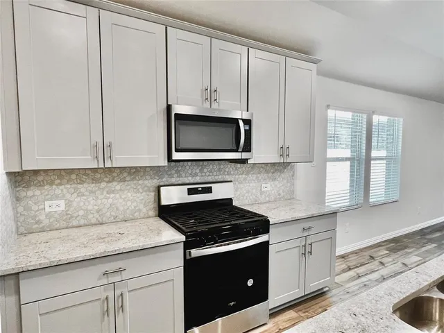 a kitchen with a sink stove and microwave