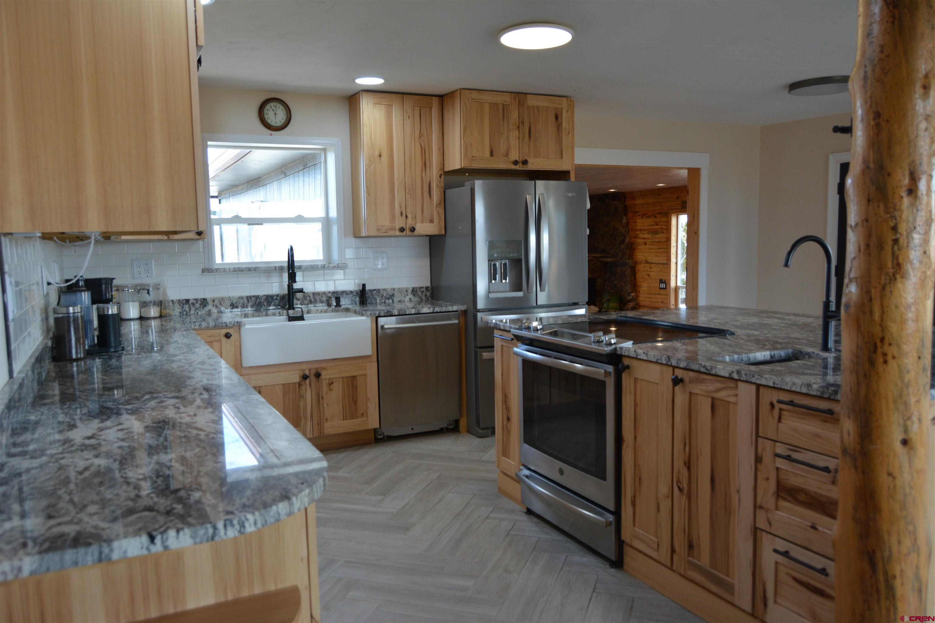 10053 2100th Road Austin, CO 81410 - Photo 12 of 41 a kitchen with stainless steel appliances granite countertop a stove a sink dishwasher and a refrigerator
