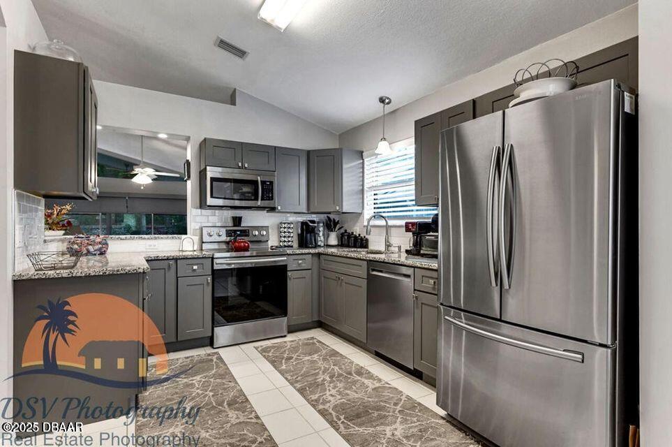 27 Reflections Village Drive Ormond Beach, FL 32174 - Photo 4 of 29 a kitchen with stainless steel appliances granite countertop a refrigerator a stove a sink and a microwave