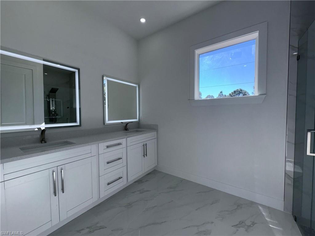 423 Harshaw Street Lehigh Acres, FL 33974 - Photo 16 of 27 a bathroom with a sink and a mirror