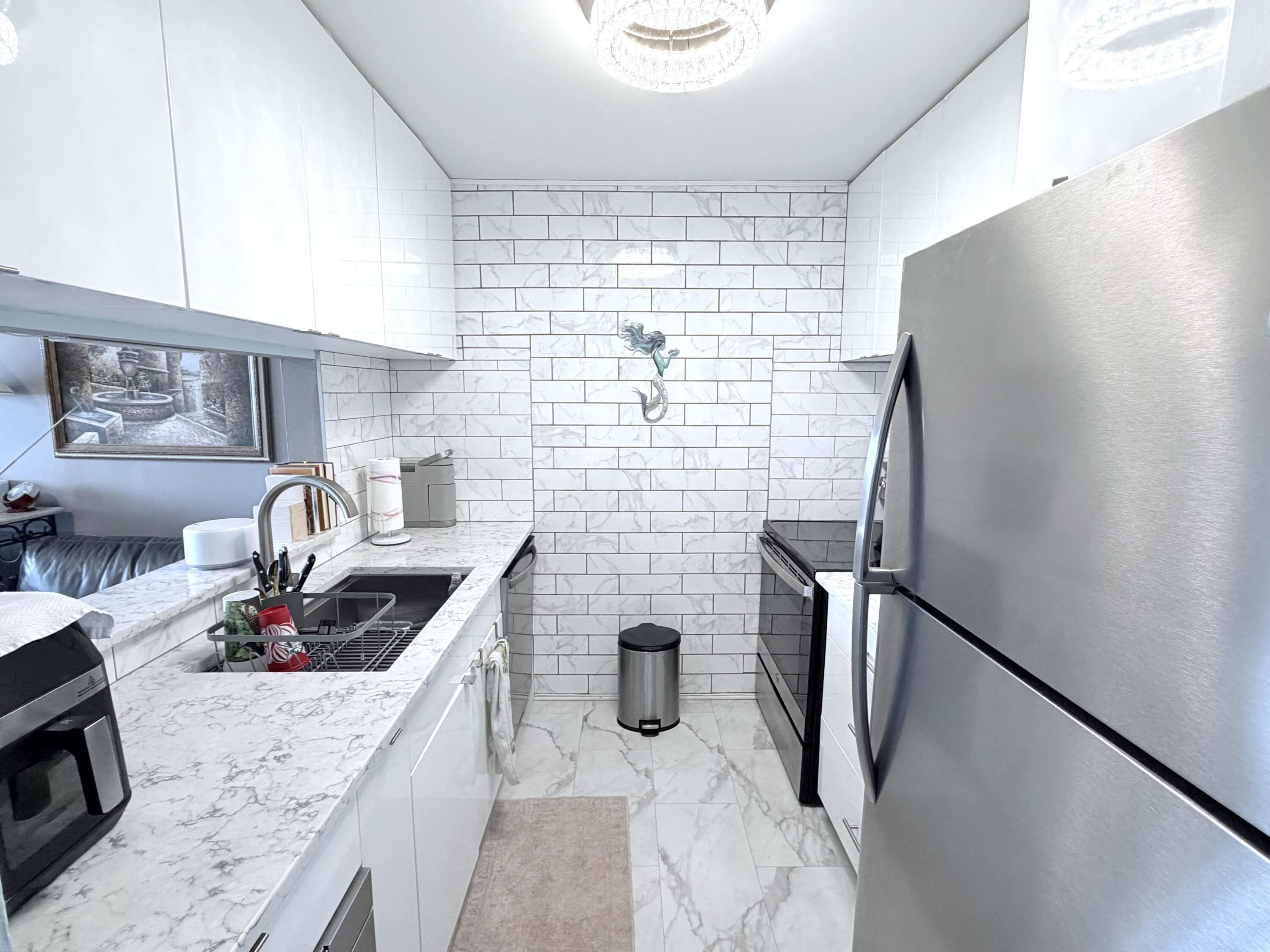 777 South Federal Highway, Unit RPH11 Pompano Beach, FL 33062 - Photo 2 of 32 a kitchen with stainless steel appliances granite countertop a refrigerator and a sink