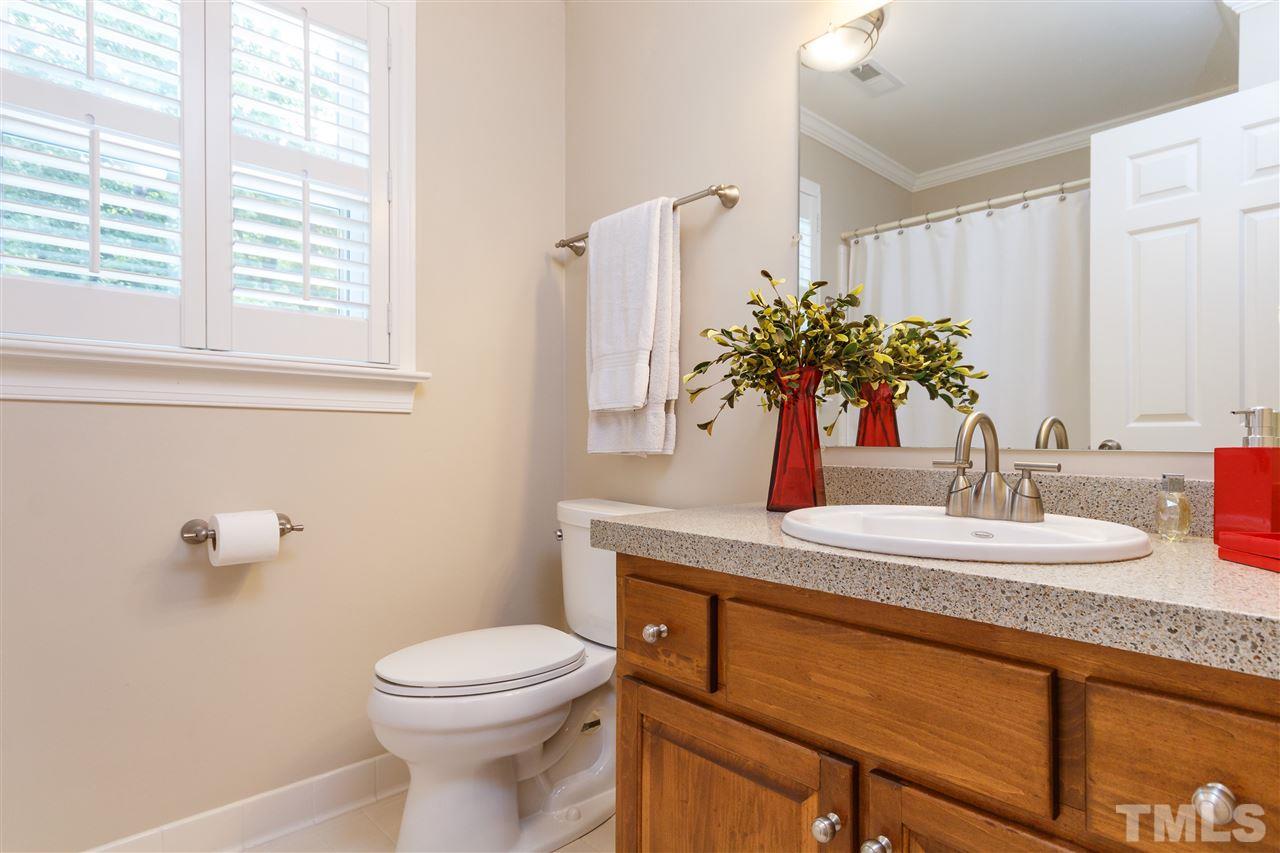 812 Misty Isle Place Raleigh, NC 27615 - Photo 17 of 25 a bathroom with a granite countertop sink toilet and mirror