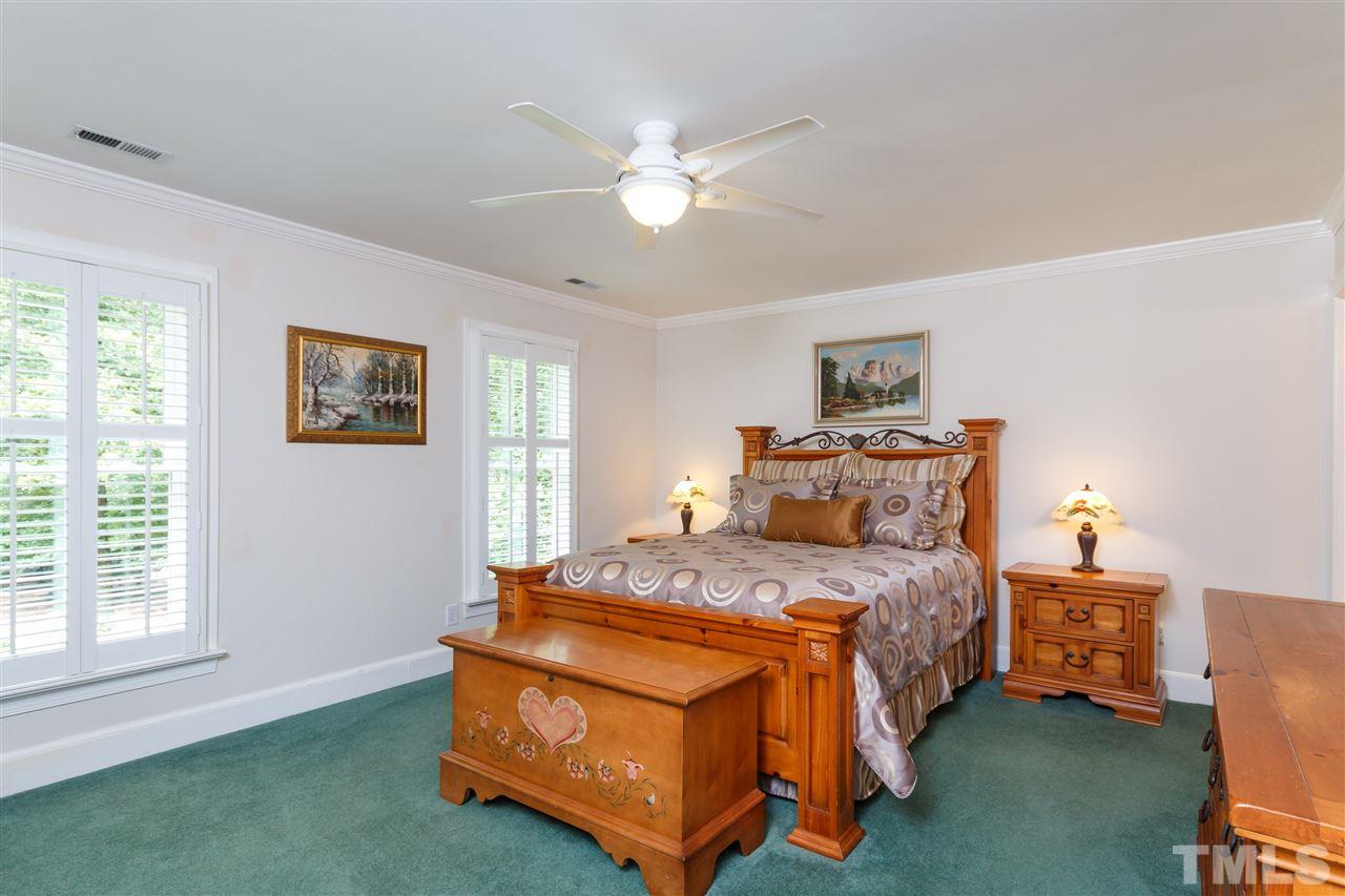 812 Misty Isle Place Raleigh, NC 27615 - Photo 18 of 25 a bedroom with a bed and a chandelier