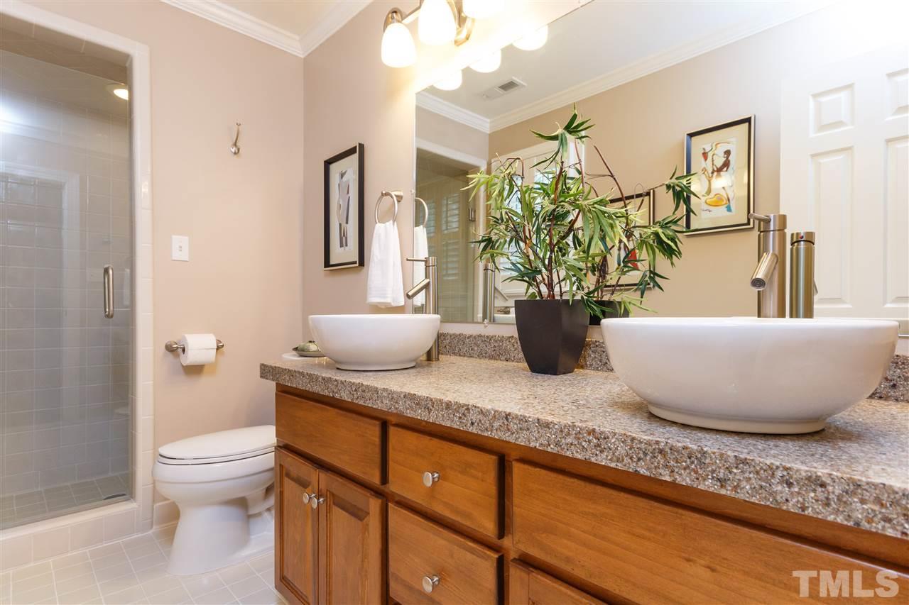 812 Misty Isle Place Raleigh, NC 27615 - Photo 19 of 25 a bathroom with a granite countertop sink a toilet and a mirror