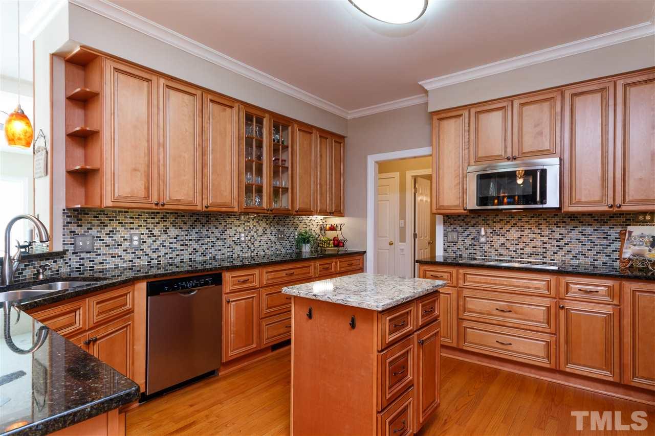 812 Misty Isle Place Raleigh, NC 27615 - Photo 7 of 25 a kitchen with stainless steel appliances granite countertop a stove a sink and a microwave