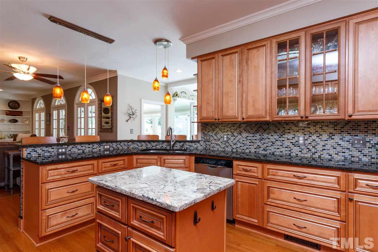 812 Misty Isle Place Raleigh, NC 27615 - Photo 8 of 25 a kitchen with stainless steel appliances granite countertop a coffee maker on granite counter tops and a view of living room
