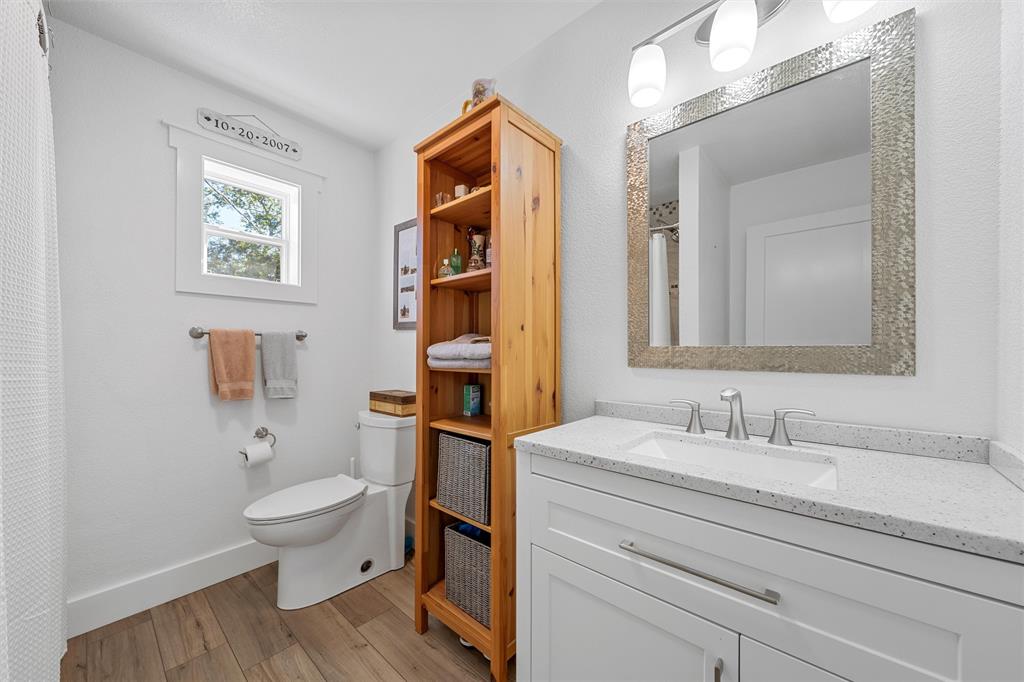 111 North Avenue R Clifton, TX 76634 - Photo 14 of 27 a bathroom with a toilet a sink and mirror