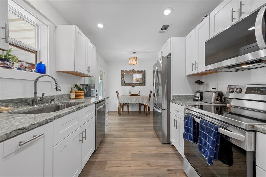 111 North Avenue R Clifton, TX 76634 - Photo 9 of 27 a large kitchen with stainless steel appliances granite countertop a lot of counter space and wooden floor