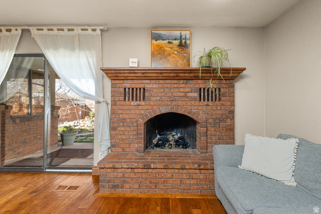 892 Cambridge Drive St. George, UT 84770 - Photo 22 of 65 Brick fireplace with a wood mantel, arched firebox, and a raised brick hearth