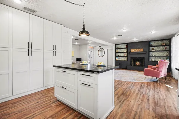 a kitchen with stainless steel appliances granite countertop a stove cabinets and wooden floor