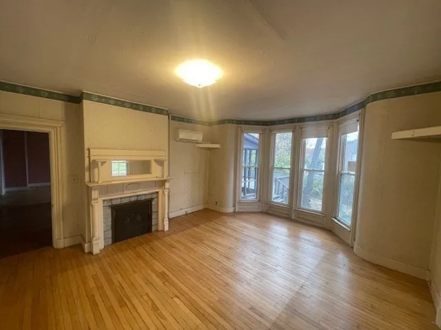 a view of an empty room with a fireplace and a window