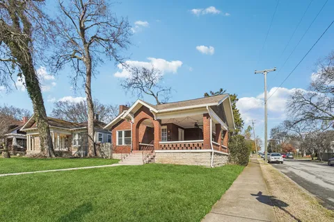 a view of a white house with a yard and many windows