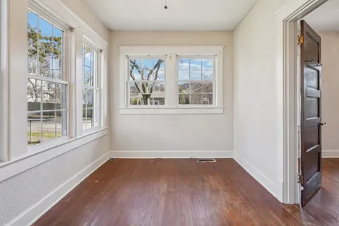 an empty room with wooden floor and closet