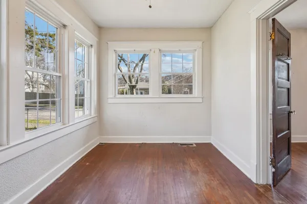 an empty room with wooden floor and closet