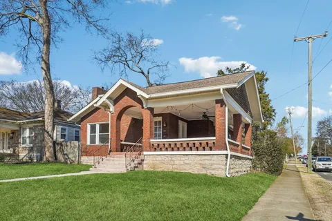 a front view of a house with a garden and yard