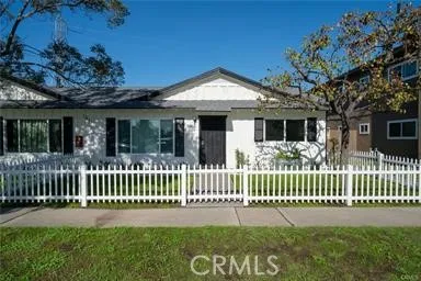 a view of a house with a small yard and a large tree