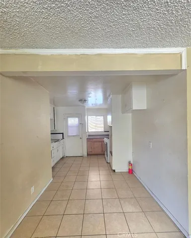 a view of a livingroom with wooden floor and a refrigerator