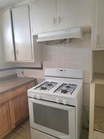 a white stove top oven sitting inside of a kitchen