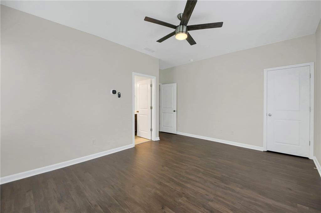 2042 Bolton Road Northwest Atlanta, GA 30318 - Photo 15 of 30 an empty room with wooden floor and ceiling fan