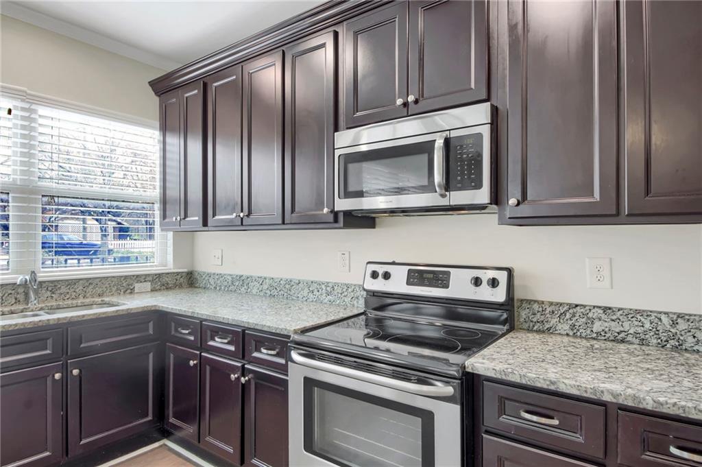 2042 Bolton Road Northwest Atlanta, GA 30318 - Photo 8 of 30 a kitchen with granite countertop cabinets stainless steel appliances and window
