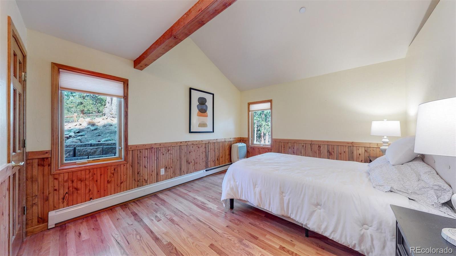 153 Ski Road East Allenspark, CO 80510 - Photo 21 of 40 a bedroom with a large bed and wooden floor