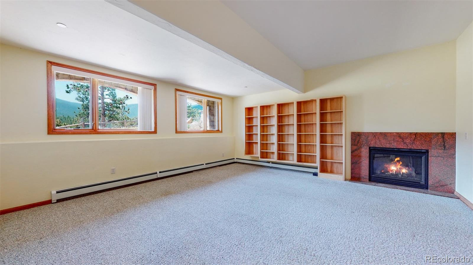 153 Ski Road East Allenspark, CO 80510 - Photo 31 of 40 a view of an empty room with a fireplace and a window
