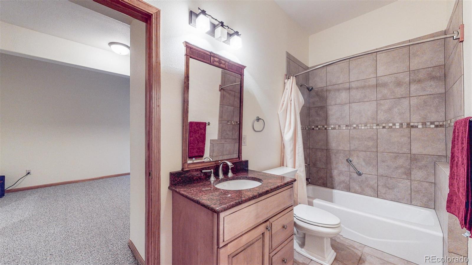 153 Ski Road East Allenspark, CO 80510 - Photo 35 of 40 a bathroom with a granite countertop sink toilet mirror and shower