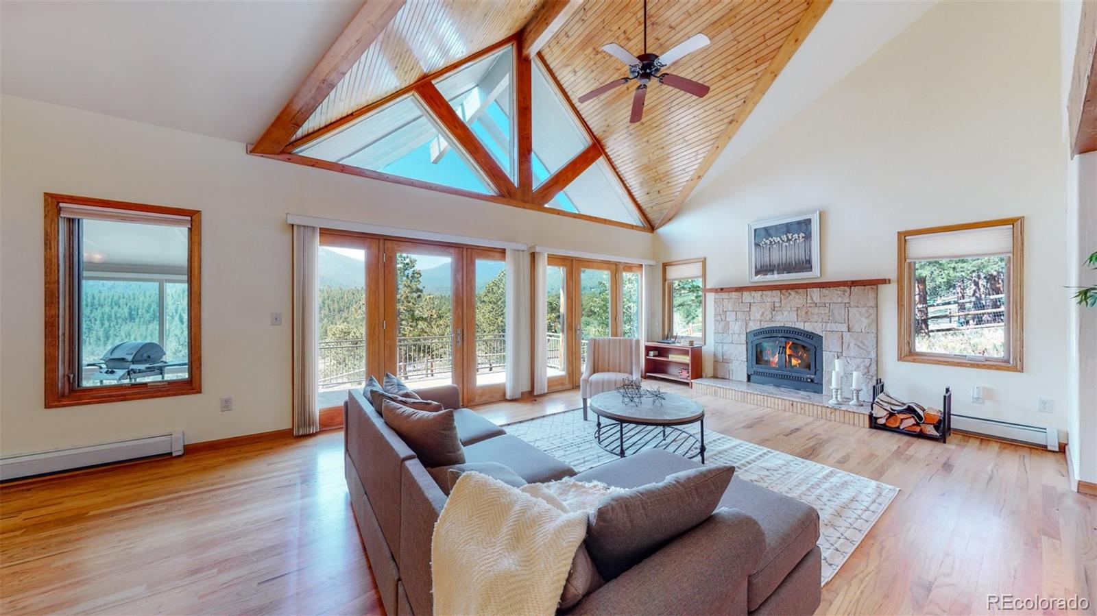 153 Ski Road East Allenspark, CO 80510 - Photo 5 of 40 a living room with furniture a fireplace and a large window