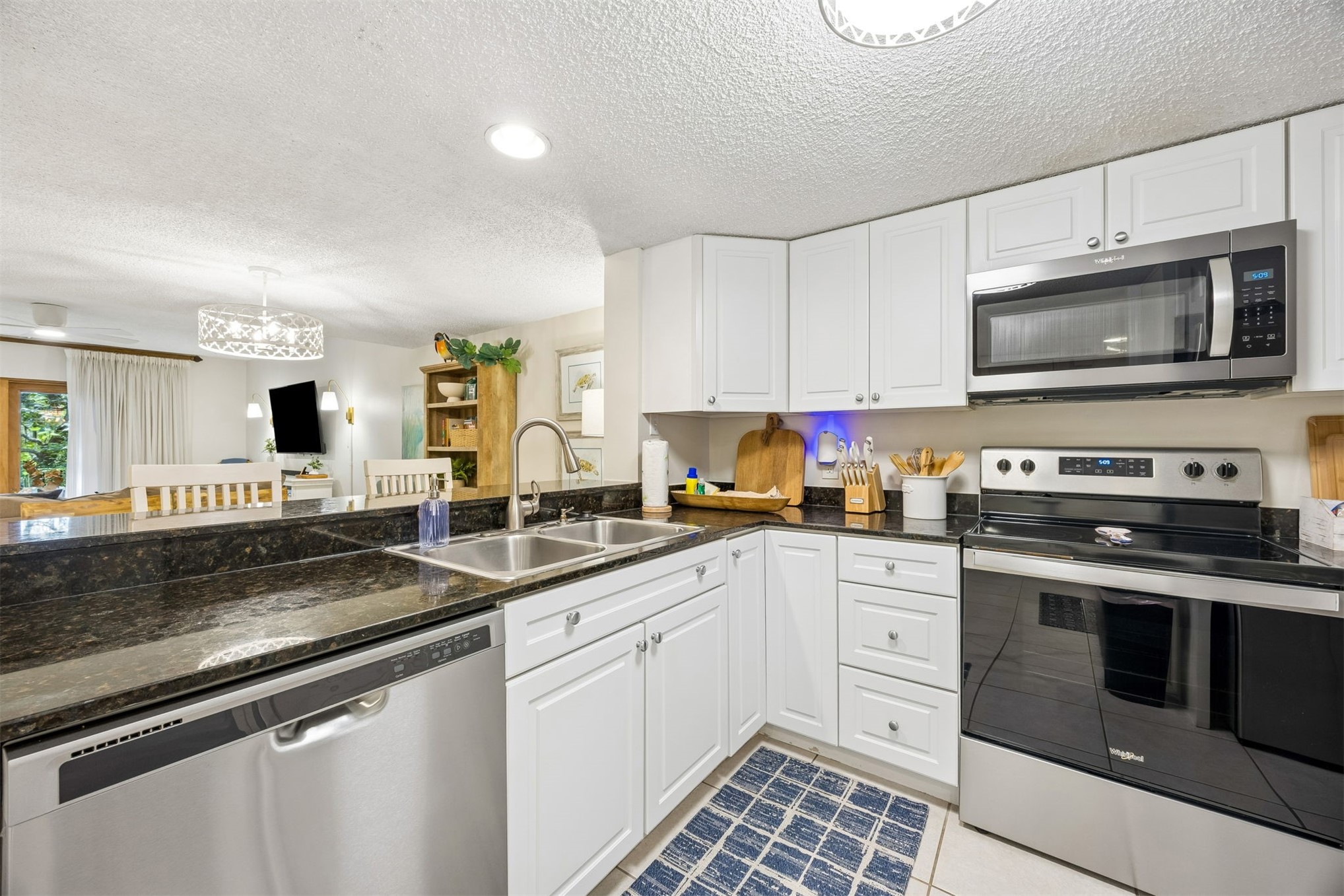 2014 Beachwood Road, Unit 2014 Amelia Island, FL 32034 - Photo 12 of 36 a kitchen with granite countertop a sink stainless steel appliances and white cabinets