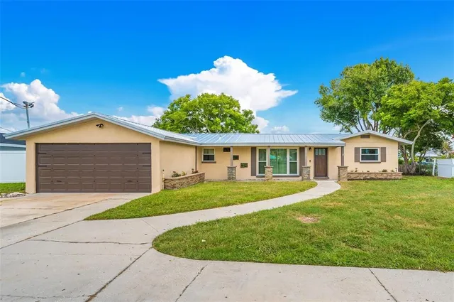 a front view of a house with a garden and trees
