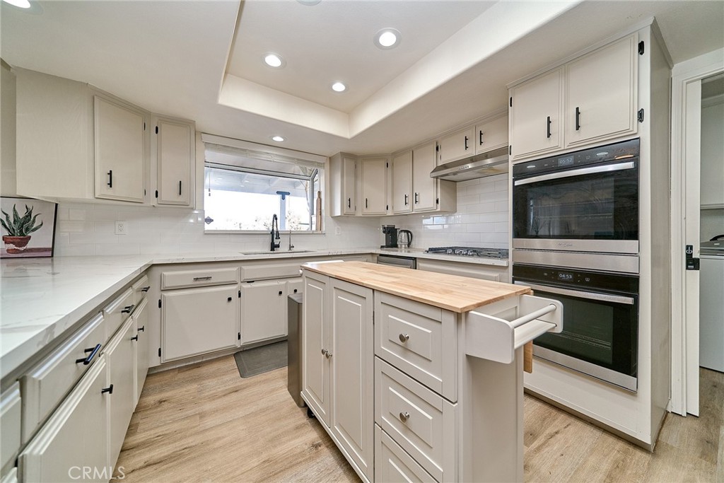 9783 Corton Street Phelan, CA 92371 - Photo 14 of 29 a kitchen with stainless steel appliances granite countertop a stove and a sink
