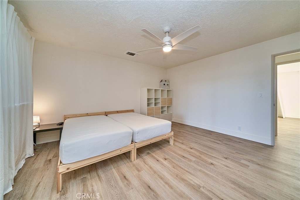 9783 Corton Street Phelan, CA 92371 - Photo 22 of 29 a bedroom with a bed and a chandelier