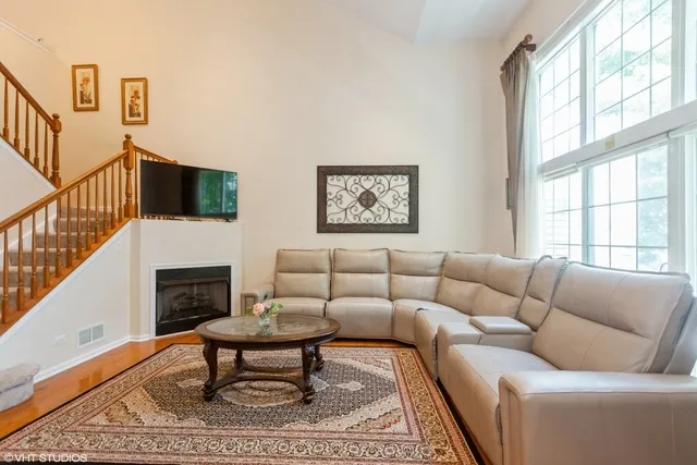 a living room with furniture a rug a window and a fireplace