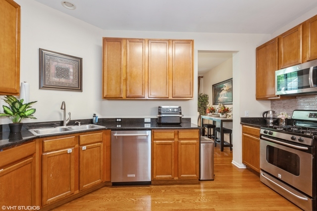152 Orchards Pass Bartlett, IL 60103 - Photo 10 of 40 a kitchen with granite countertop cabinets stainless steel appliances a sink and a potted plant